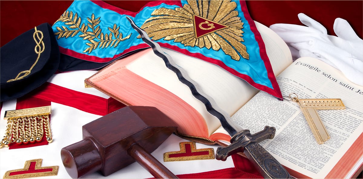 Regalia masónica de la Logia: mandil, collar, mallete, espada y Libro de la Ley Sagrada.